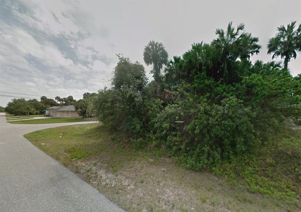 A vacant, overgrown corner lot with dense vegetation and palm trees in a residential neighborhood — Lot 12 KAABE AVENUE, NORTH PORT, FL