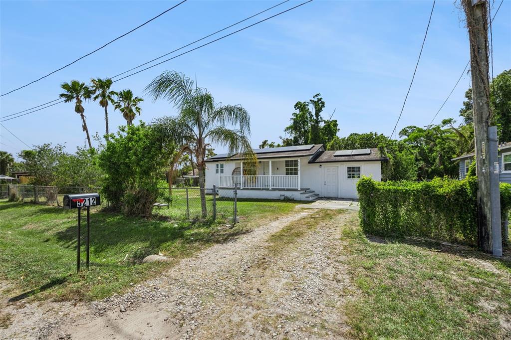 A white single-story house with a gravel driveway and a fenced yard — 5212 ALOHA STREET, ORLANDO, FL