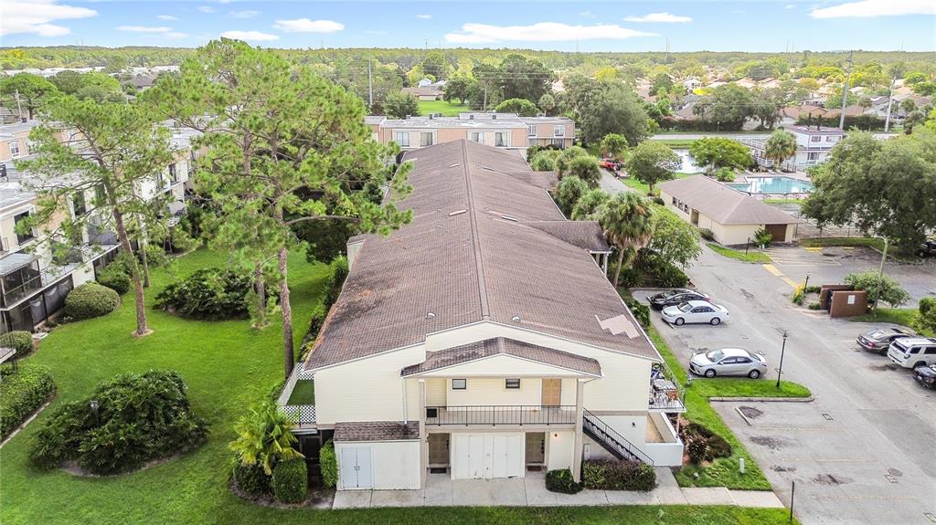 An aerial view of a multi-story apartment building with a brown roof and parking lot — 5977 VILLAGE CIRCLE SOUTH UNIT GE, ORLANDO, FL