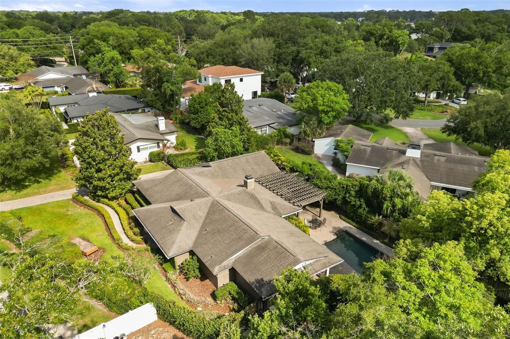 An aerial view shows a house with a shingled roof, pergola, and backyard swimming pool — 119 HOLLIE COURT, MAITLAND, FL