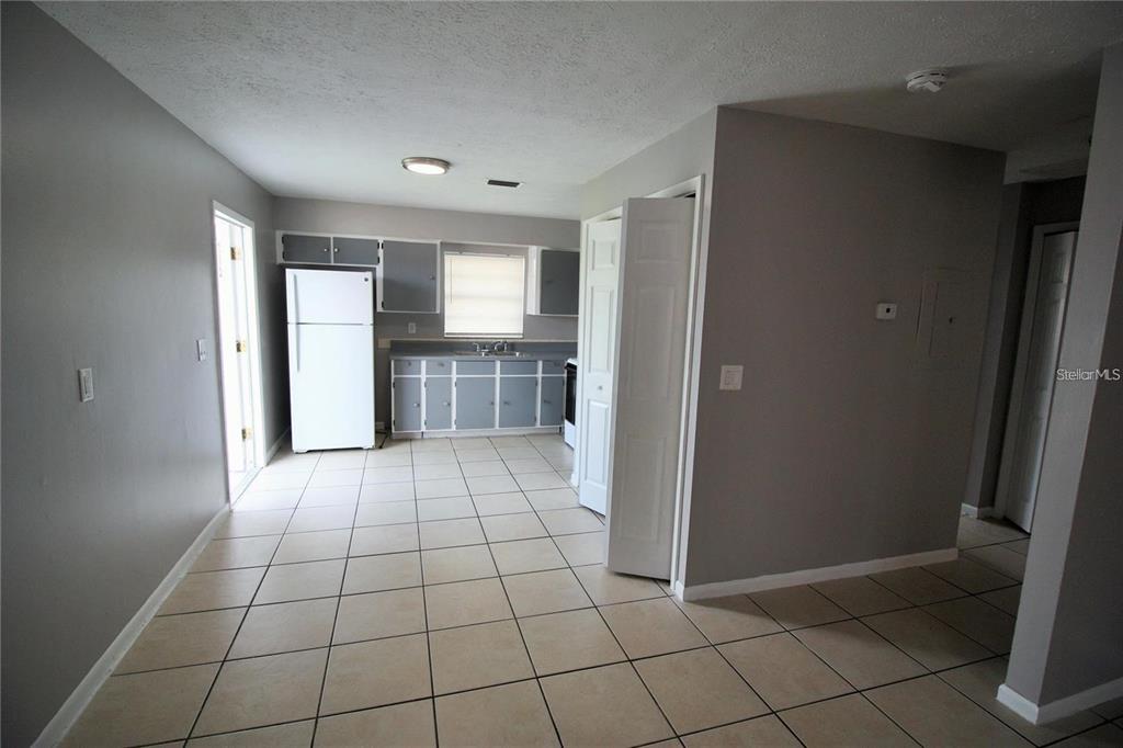 A kitchen features gray cabinets, white appliances, and light-colored tile flooring — 9418 N 50TH STREET UNIT B, TAMPA, FL