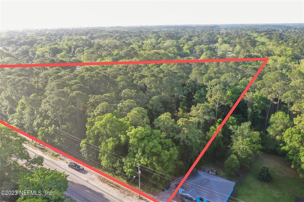 An aerial view shows a wooded lot outlined in red next to a road — 901 W KING STREET, ST AUGUSTINE, FL