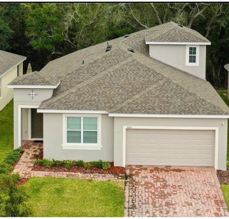 An aerial view of a single-story house with a gray stucco exterior and shingled roof — 3215 STRATTON CIRCLE, KISSIMMEE, FL