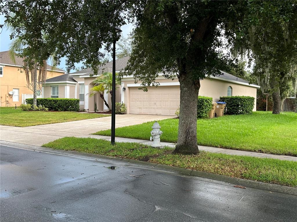 A single-story house with a beige exterior, a two-car garage, and a front lawn — 3127 CONRAD COURT, KISSIMMEE, FL