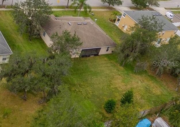 An aerial view shows a residential house with a screened-in porch and a large backyard — 3127 CONRAD COURT, KISSIMMEE, FL