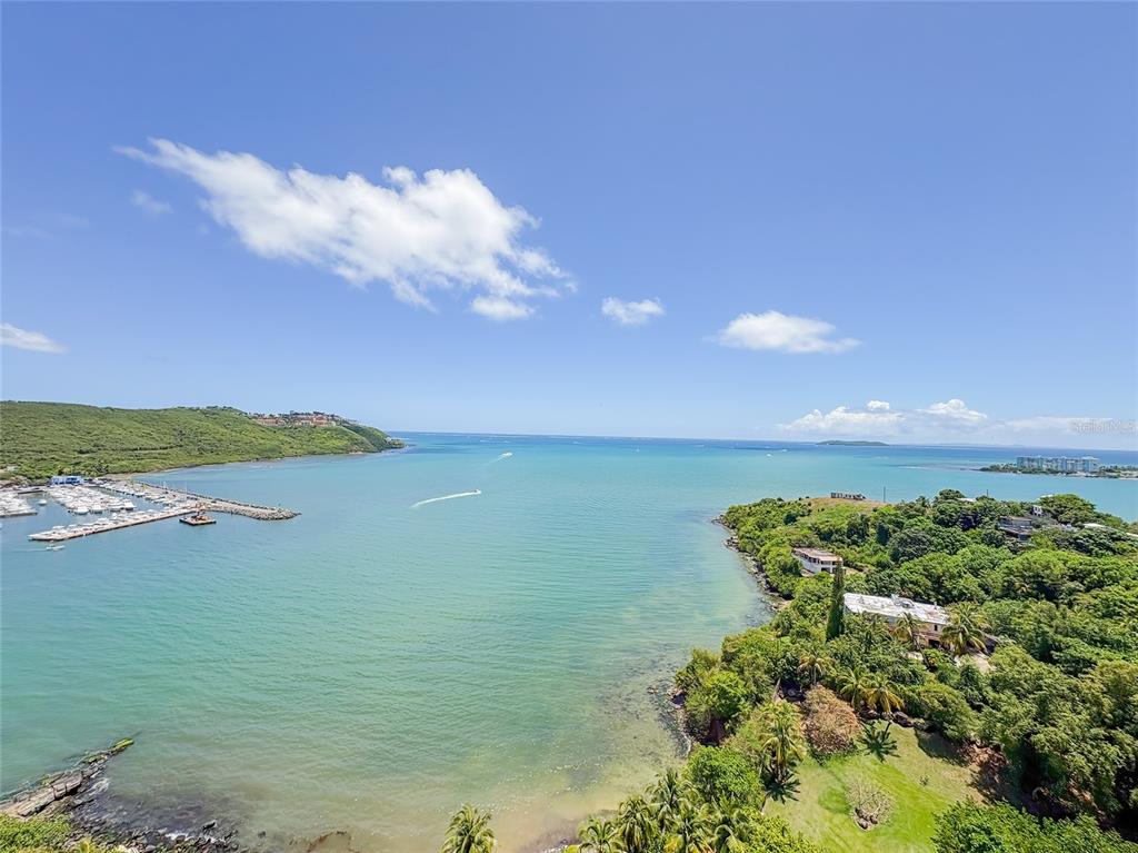 An aerial view shows a coastal bay with a marina, lush greenery, and blue water — 200 MARINA VW AVE. UNIT 1910, FAJARDO, PR