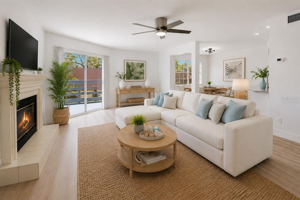 A bright living room features a white sectional sofa, a fireplace, and a dining area — 14510 ALEJO COURT, SEMINOLE, FL