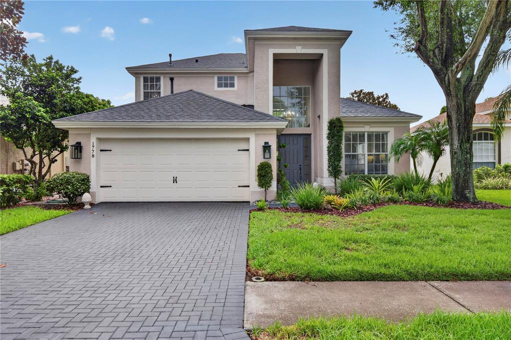 A two-story house features a gray shingled roof, a paved driveway, and a front entrance — 1778 BRILAND STREET, TARPON SPRINGS, FL