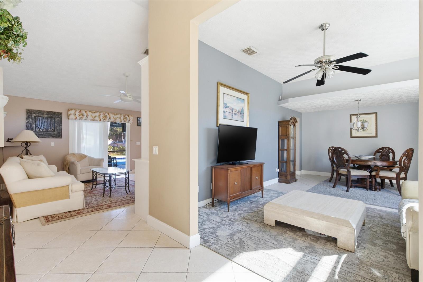 A living room and dining area feature tile floors, a ceiling fan, and gray walls — 1569 NE Amy Avenue, Jensen Beach FL 34957, JENSEN BEACH, FL