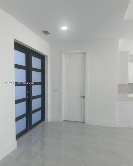 An interior view showing a double front door with frosted glass panels and a white door — 2002 E 13th St, Lehigh Acres FL 33972, LEHIGH ACRES, FL