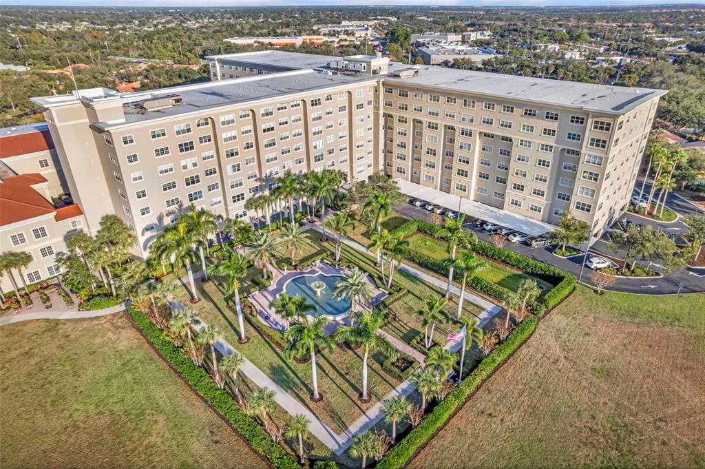 An aerial view shows a large multi-story building with a central courtyard and fountain — 3730 CADBURY CIRCLE UNIT 431, VENICE, FL