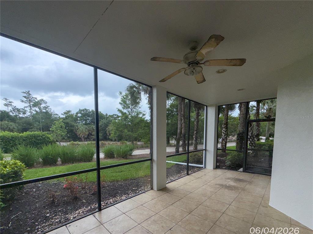 A screened-in patio with tile flooring, a ceiling fan, and a view of trees — 12219 TOSCANA WAY UNIT 103, BONITA SPRINGS, FL