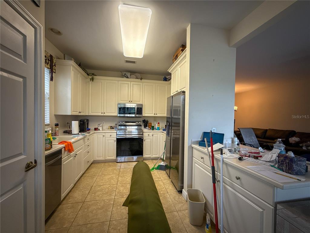 A kitchen with white cabinets, stainless steel appliances, and tile flooring — 12219 TOSCANA WAY UNIT 103, BONITA SPRINGS, FL