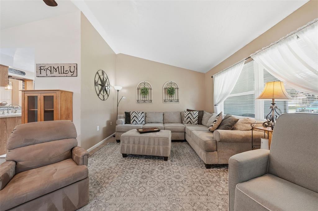 A living room features a sectional sofa, an ottoman, and two armchairs on a rug — 42 S J KELLNER BOULEVARD, BEVERLY HILLS, FL