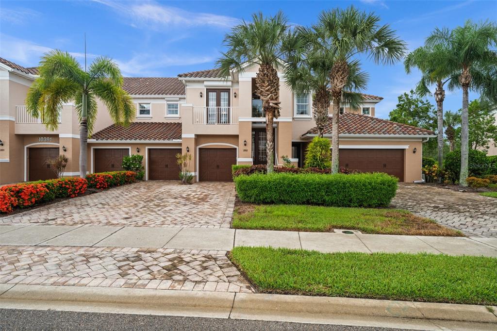 A screened-in patio with tile flooring, ceiling fans, and a view of a pond — 10391 GLASTONBURY CIRCLE UNIT 202, FORT MYERS, FL