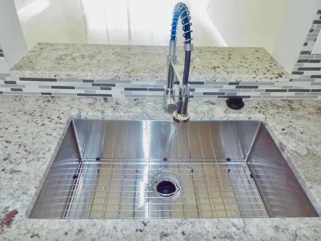 A stainless steel kitchen sink with a pull-down faucet set in a granite countertop — 3350 Perimeter Drive # 1323, FL 33467, FL
