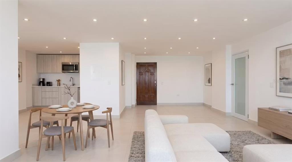 A modern open-concept living and dining area with light tile floors and a neutral kitchen — PH 807B PLAYA DORADA, CAROLINA, PR