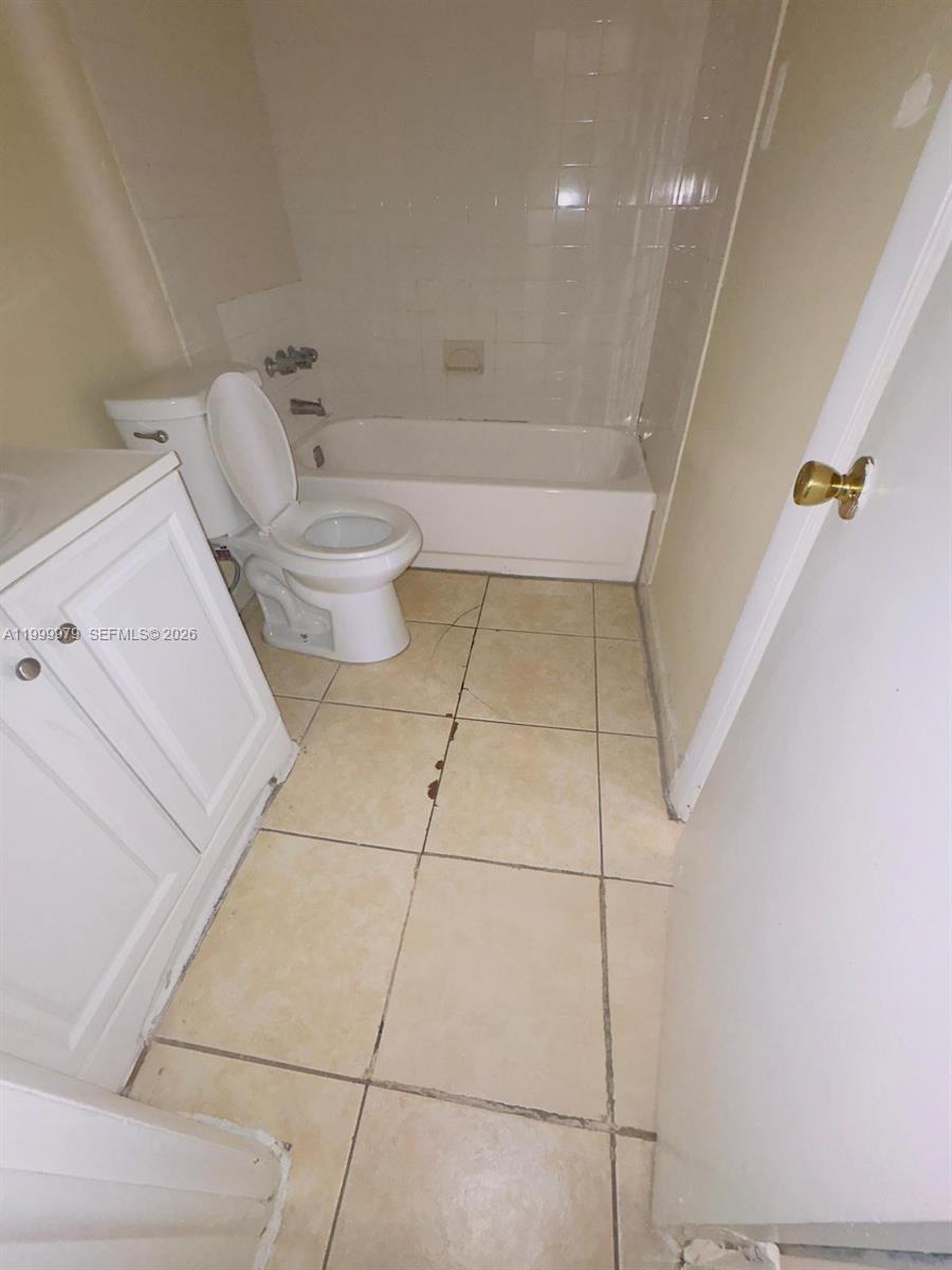 A bathroom features a white vanity, a toilet, and a bathtub with tiled walls — 19841 SW 114th Ave # 310, Miami FL 33157, MIAMI, FL