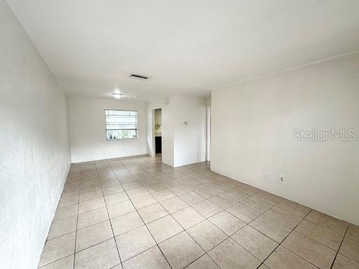 An empty room with white walls and light-colored square floor tiles — 1221 KENNEDY ROAD UNIT 48, DAYTONA BEACH, FL