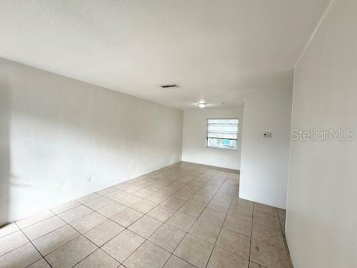An empty room with white walls, a light-colored tiled floor, and a single window — 1221 KENNEDY ROAD UNIT 48, DAYTONA BEACH, FL