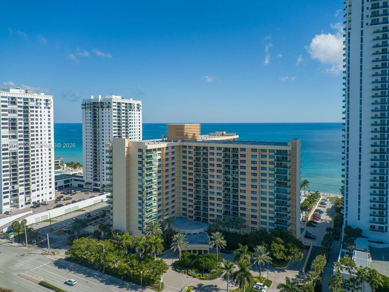 An aerial view of a multi-story residential building near the ocean with surrounding palm trees — 2501 S Ocean Dr, Hollywood FL 33019, HOLLYWOOD, FL