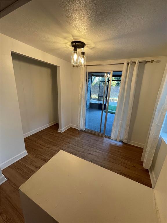 A dining area features wood-look flooring, a modern light fixture, and sliding glass patio doors — 23108 DOVER DRIVE, LAND O LAKES, FL