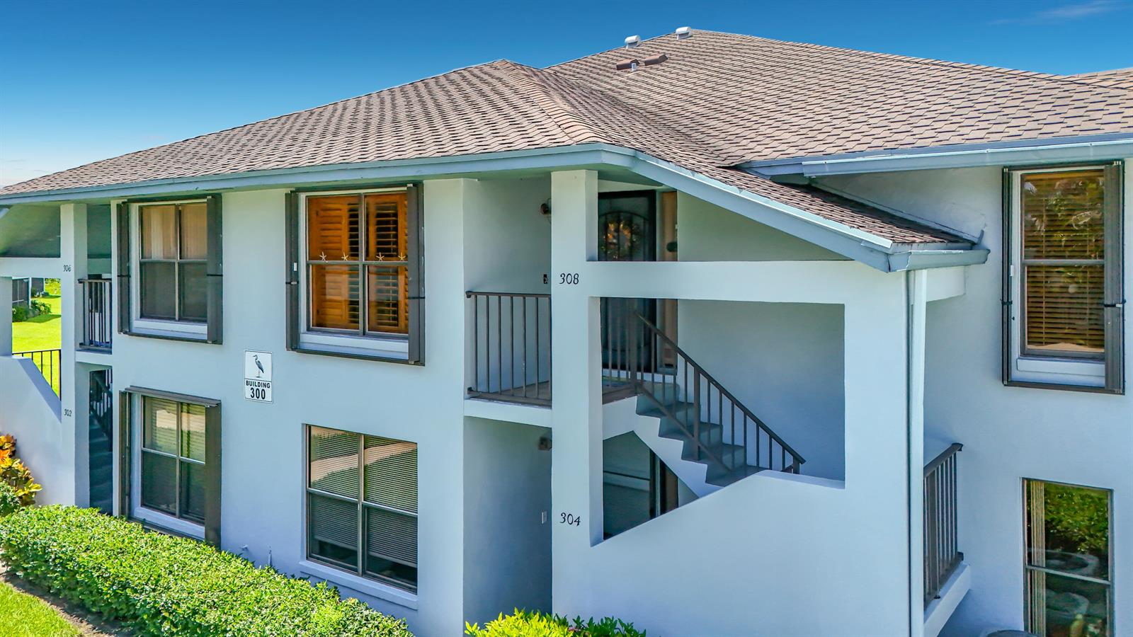 An exterior view of a two-story apartment building with a staircase and numbered units — 950 S Kanner Highway # 308, Stuart FL 34994, STUART, FL