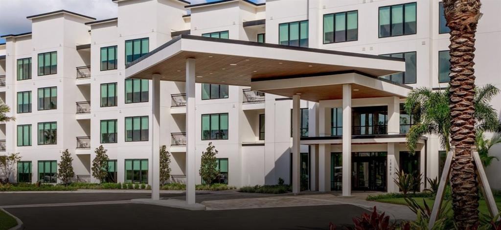 Exterior view of a modern multi-story apartment building with a large covered entrance portico — 14501 GROVE RESORT AVENUE UNIT 3714, WINTER GARDEN, FL