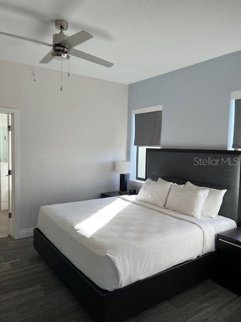 A bedroom features a bed with a dark headboard, a ceiling fan, and light-colored walls — 14501 GROVE RESORT AVENUE UNIT 3714, WINTER GARDEN, FL