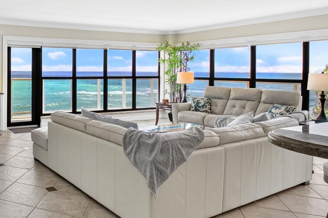 A living room with a large white sectional sofa and floor-to-ceiling windows overlooking the ocean — 4605 S Ocean Boulevard # 5a, Highland Beach FL 33487, HIGHLAND BEACH, FL
