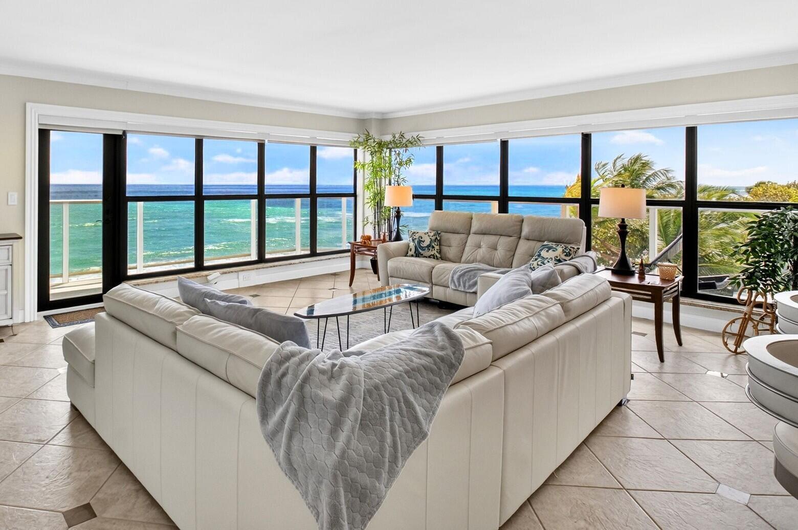 A living room with a large sectional sofa, tile floors, and panoramic ocean views — 4605 S Ocean Boulevard # 5a, Highland Beach FL 33487, HIGHLAND BEACH, FL