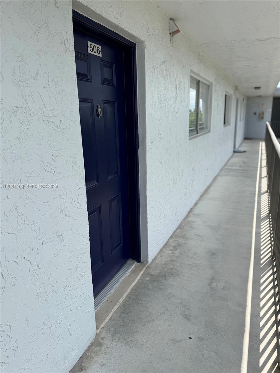A dark blue front door with the number 506 sits on an outdoor apartment walkway — 8710 N Sherman Cir # 506, Miramar FL 33025, MIRAMAR, FL