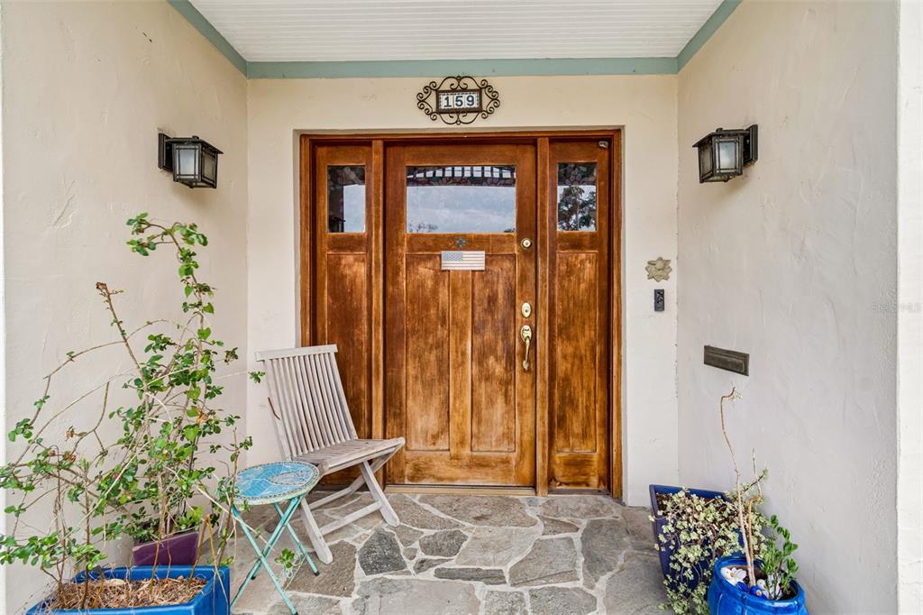 A wooden front door with sidelights and a stone porch sits under a covered entryway — 159 BISCAYNE AVENUE, TAMPA, FL