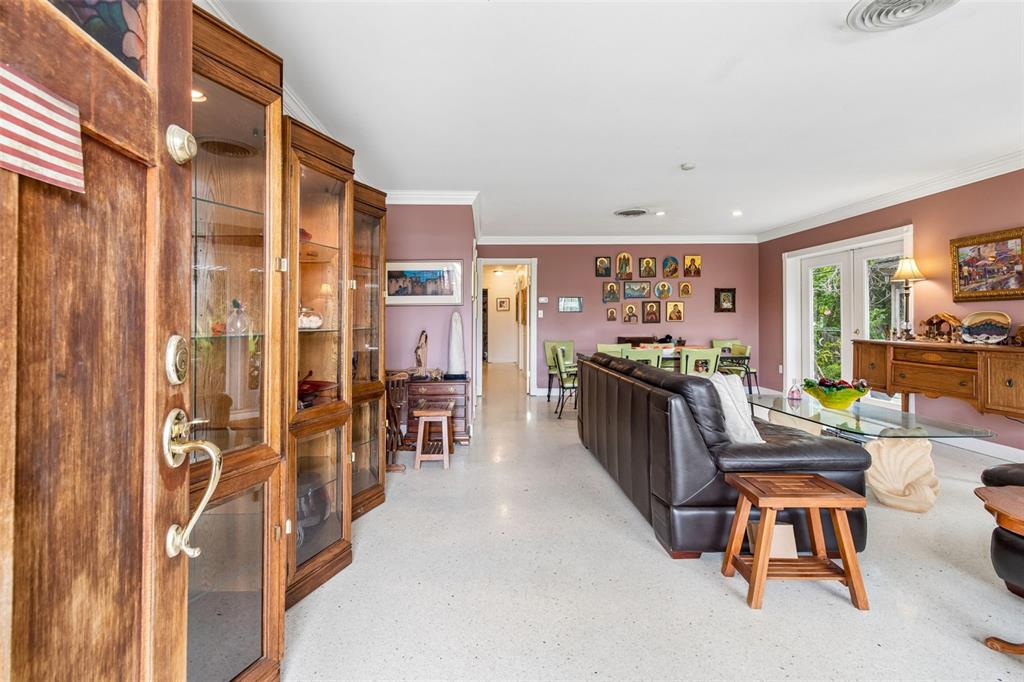 A living room features a dark leather sofa, glass-topped table, and a wall of icons — 159 BISCAYNE AVENUE, TAMPA, FL