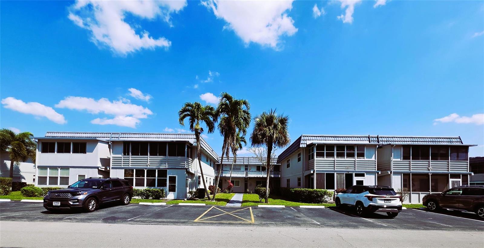 A two-story apartment complex with a parking lot in front and palm trees — 216 Tuscany # D, Delray Beach FL 33446, DELRAY BEACH, FL