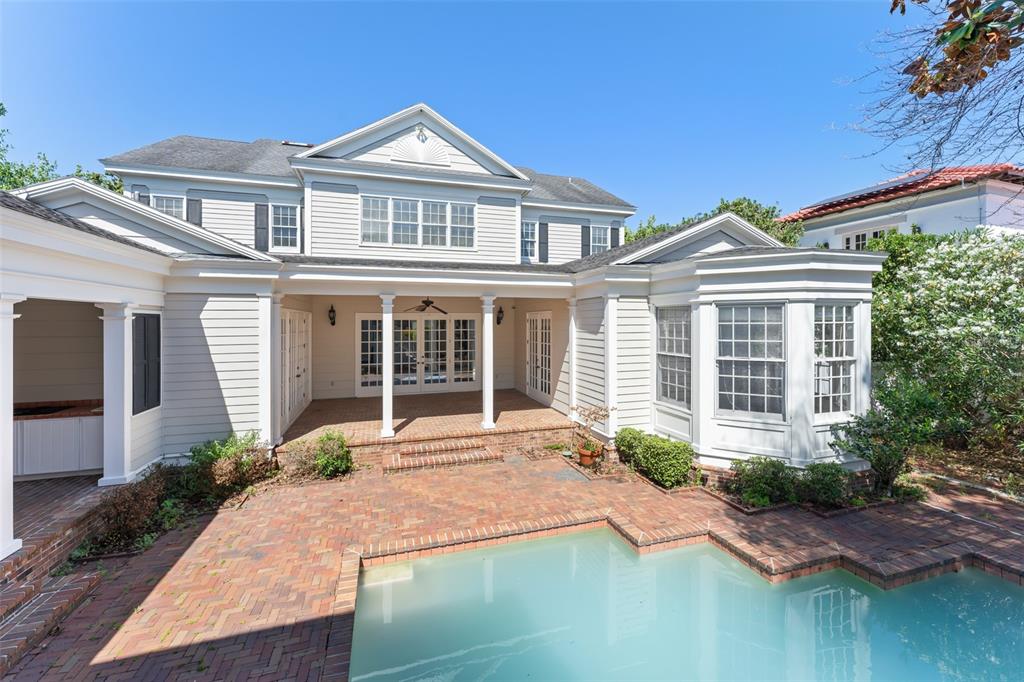 A two-story house with white siding features a brick patio and a swimming pool — 403 WATER STREET, CELEBRATION, FL