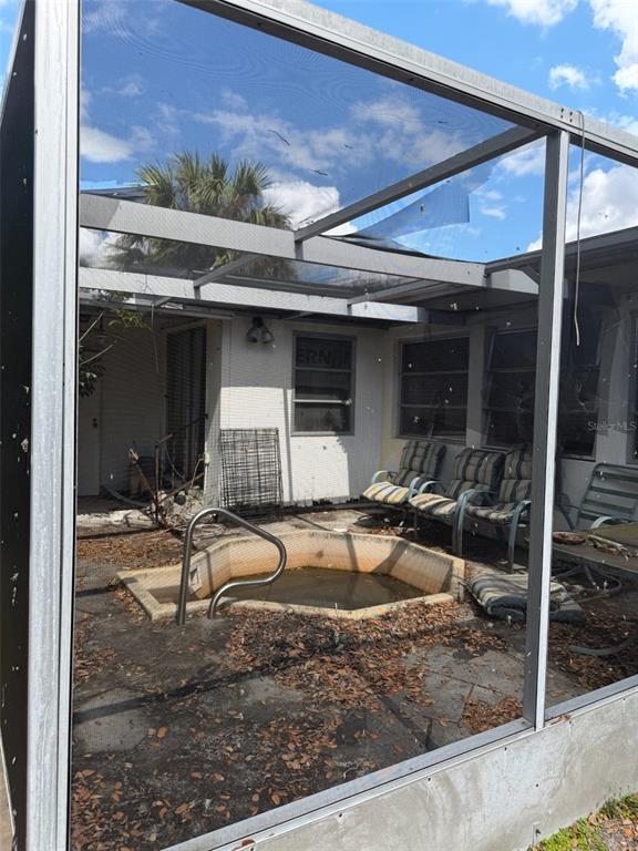 A screened-in patio features a small, in-ground pool and several outdoor chairs — 5819 HOWARD LANE, PUNTA GORDA, FL
