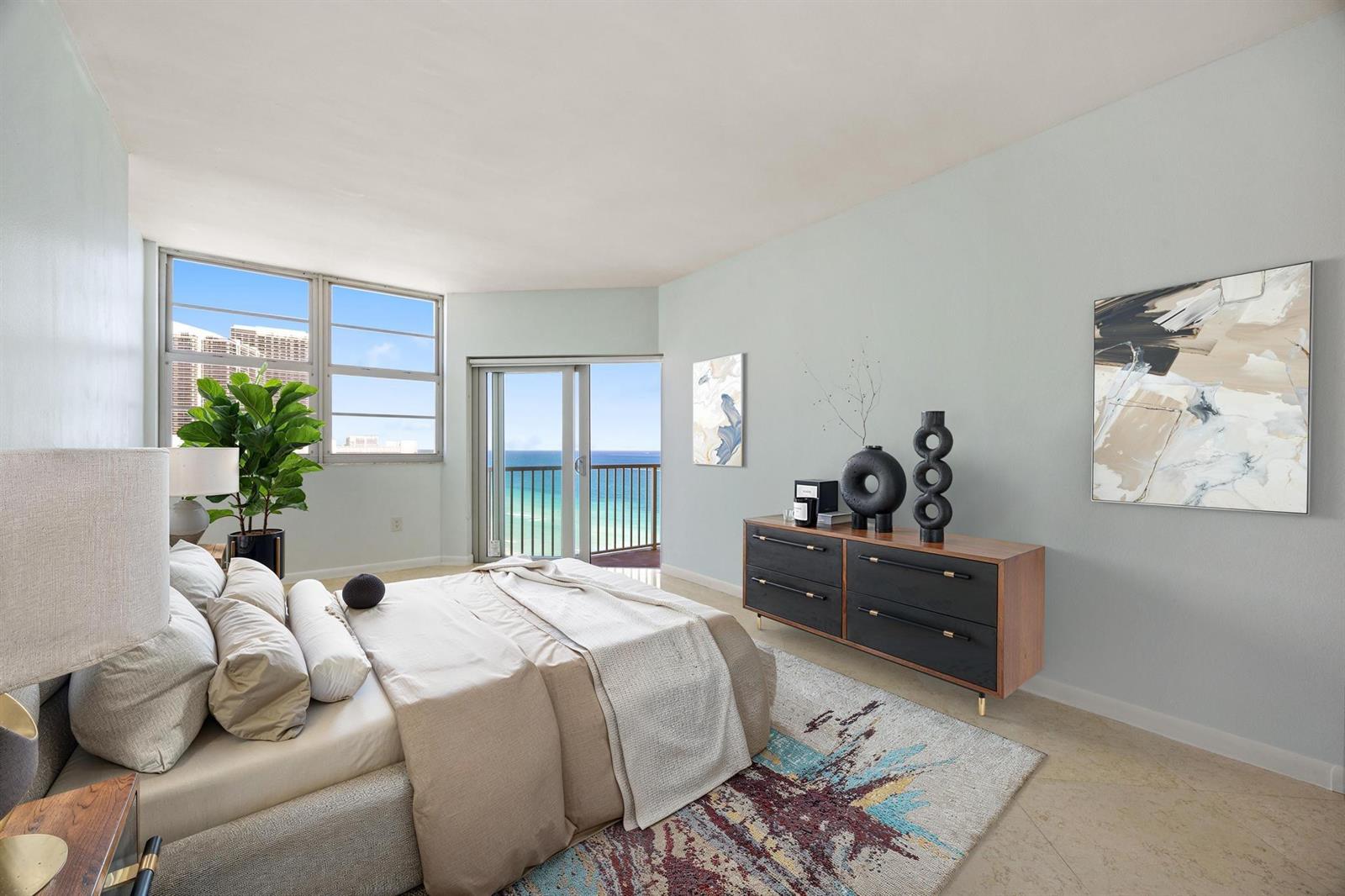 A bedroom with a bed, dresser, and balcony overlooking the ocean — 1950 S Ocean Drive, Hallandale Beach FL 33009, HALLANDALE BEACH, FL