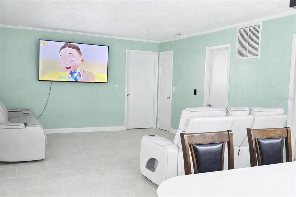 A living room features light green walls, white tile flooring, and white leather furniture — 1910 LITHIA PINECREST ROAD, VALRICO, FL