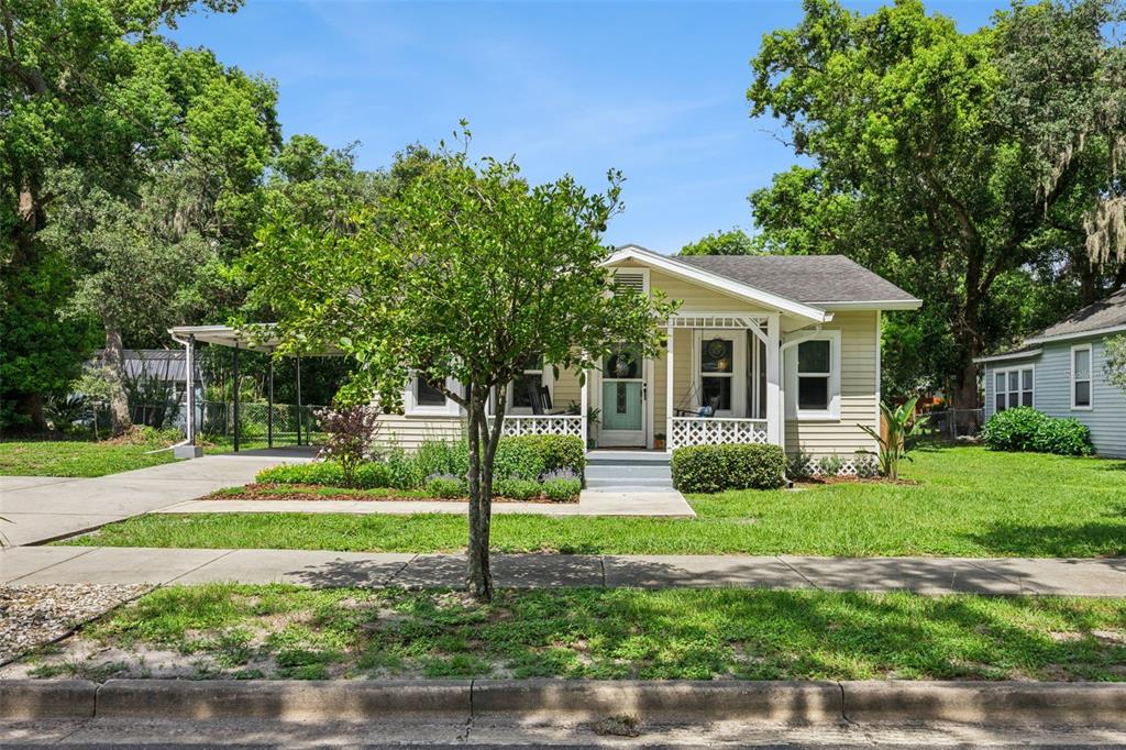 A single-story house with light yellow siding, a front porch, and a carport — 2012 S PALMETTO AVENUE, SANFORD, FL