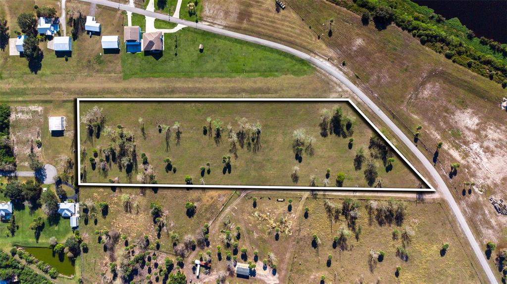 An aerial view shows a rectangular plot of land outlined in white beside a road — SW 144TH PARKWAY, OKEECHOBEE, FL