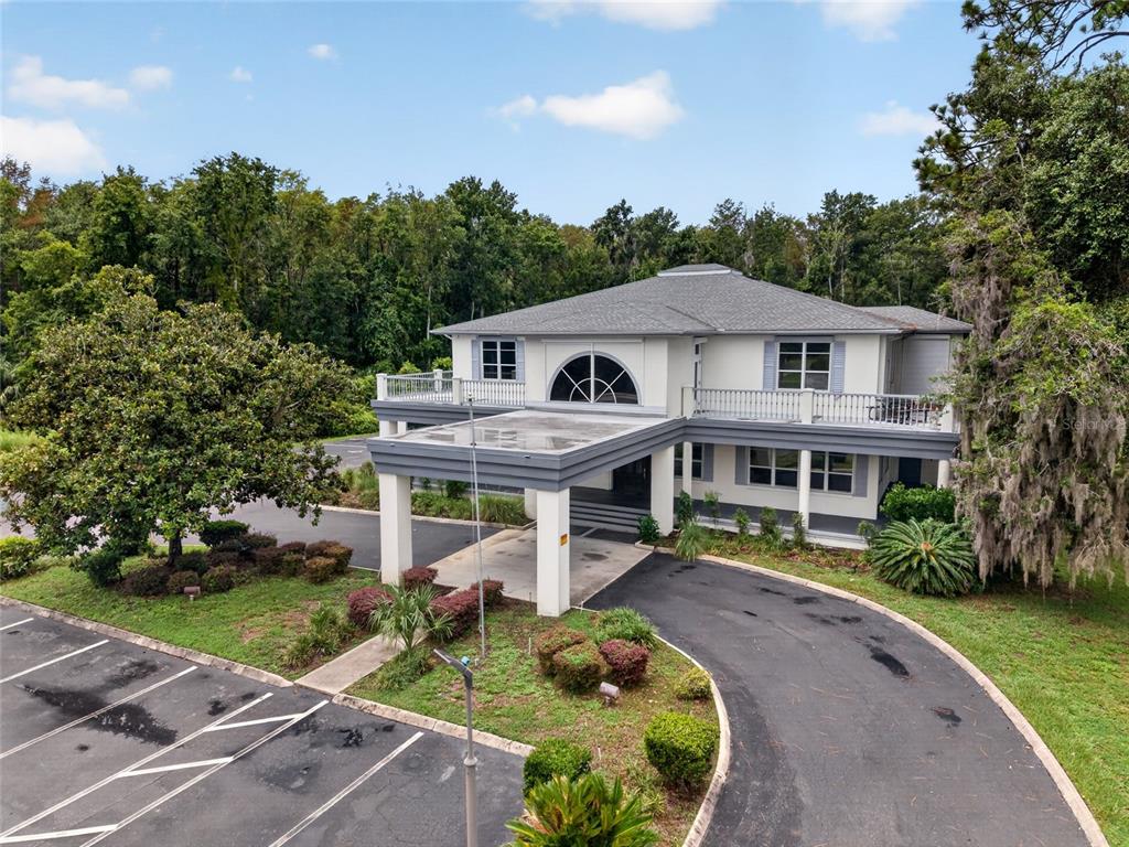 An exterior view of a two-story building with a large porte-cochère and a wrap-around balcony — 268 S SUNCOAST BOULEVARD, CRYSTAL RIVER, FL