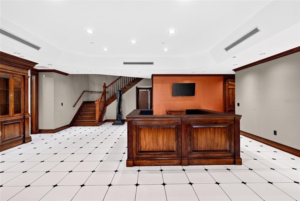 A room with a wooden bar, a staircase, and white tiled floors with black accents — 268 S SUNCOAST BOULEVARD, CRYSTAL RIVER, FL