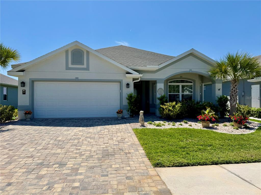 A single-story house with a paved driveway, a two-car garage, and a landscaped front yard — 36 MATANZAS LAKES DRIVE, PALM COAST, FL