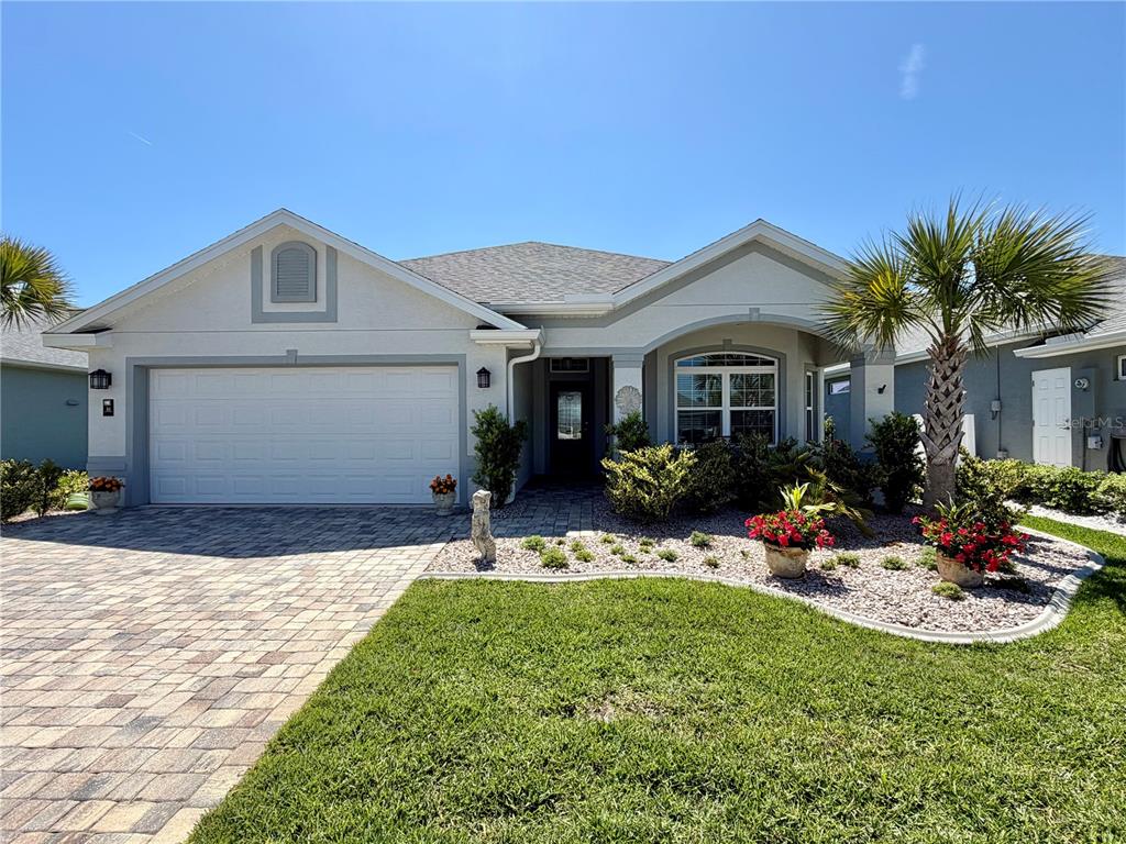 A single-story house with a paved driveway, a two-car garage, and a landscaped front yard — 36 MATANZAS LAKES DRIVE, PALM COAST, FL