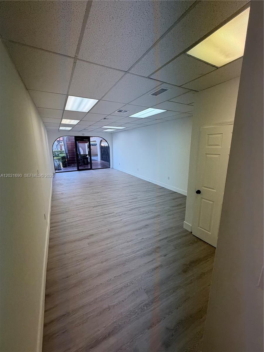 An empty office space features light wood-look flooring, white walls, and a drop ceiling — 517 SW 12th Ave, Miami FL 33130, MIAMI, FL
