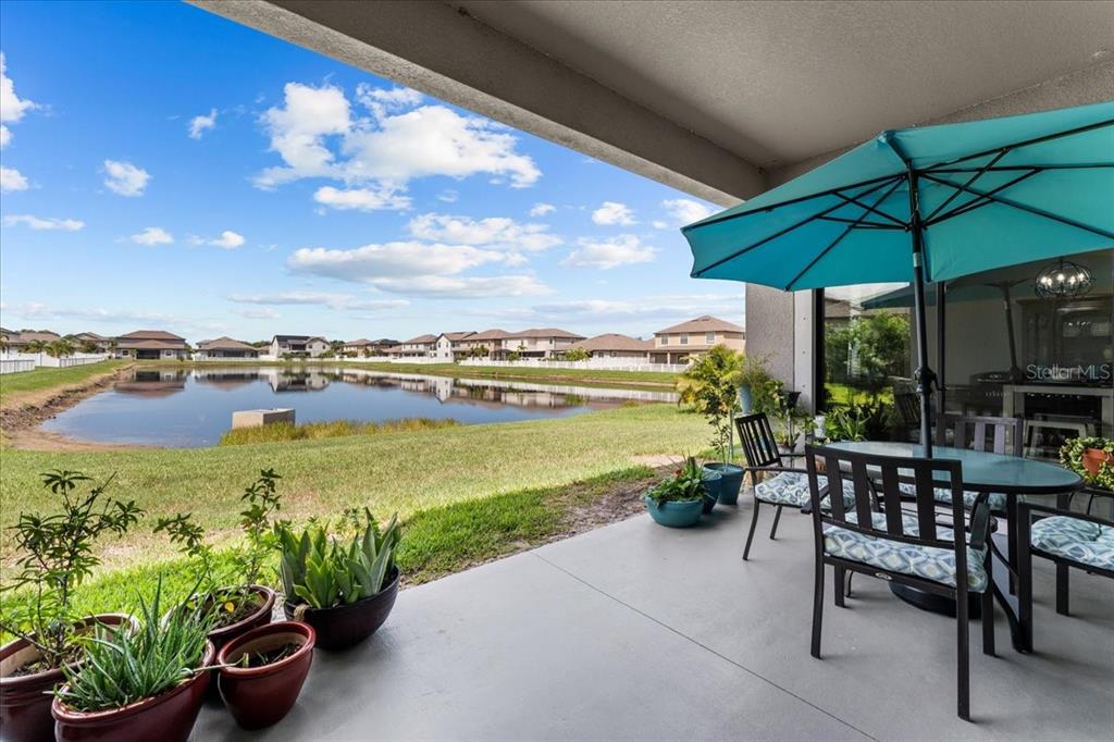 A covered patio overlooks a pond and residential houses under a blue sky — 13443 WHITE SAPPHIRE ROAD, RIVERVIEW, FL