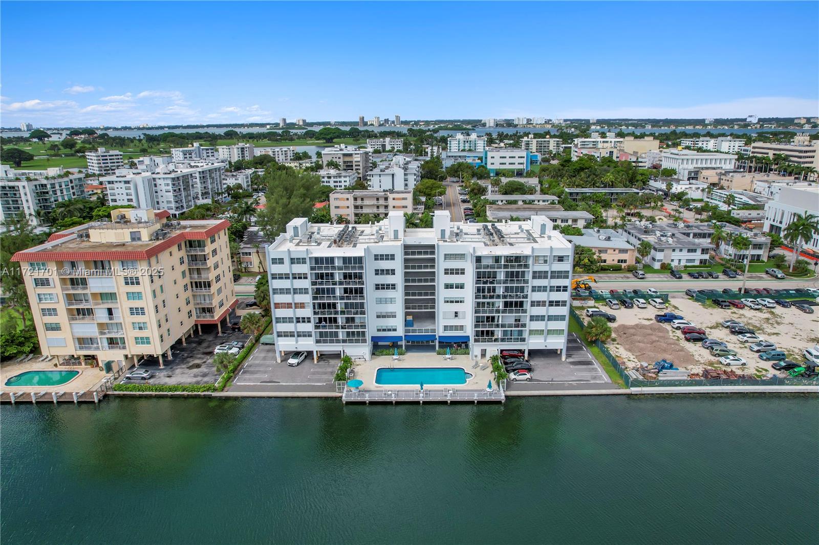 An aerial view shows two adjacent apartment buildings situated along a waterfront with a pool — 9381 E Bay Harbor Dr # 401N, Bay Harbor Islands FL 33154, BAY HARBOR ISLANDS, FL