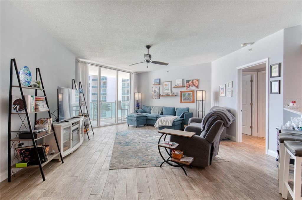 A living room features a blue sectional sofa, a gray recliner, and a balcony view — 241 RIVERSIDE DRIVE UNIT 405, HOLLY HILL, FL