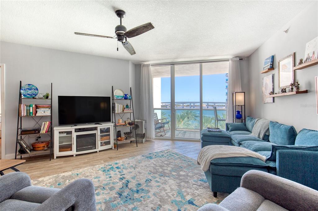 A living room features a blue sectional sofa, a television console, and a balcony view — 241 RIVERSIDE DRIVE UNIT 405, HOLLY HILL, FL
